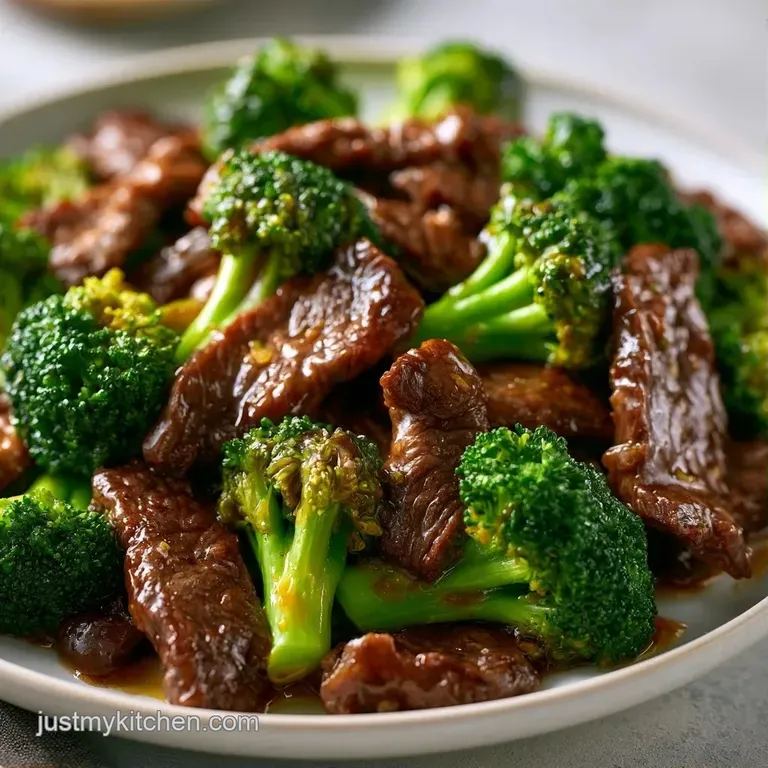 Seared beef slices and vibrant green broccoli in a dark savory glaze, elegantly plated in a shallow white bowl.