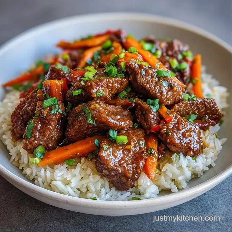 A mound of savory golden rice topped with seared beef chunks and fresh parsley on a minimalist white plate.