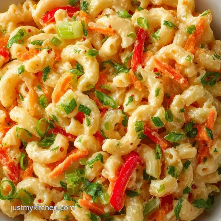 A chilled scoop of creamy pasta salad garnished with a sprig of fresh parsley on a minimalist ceramic plate.