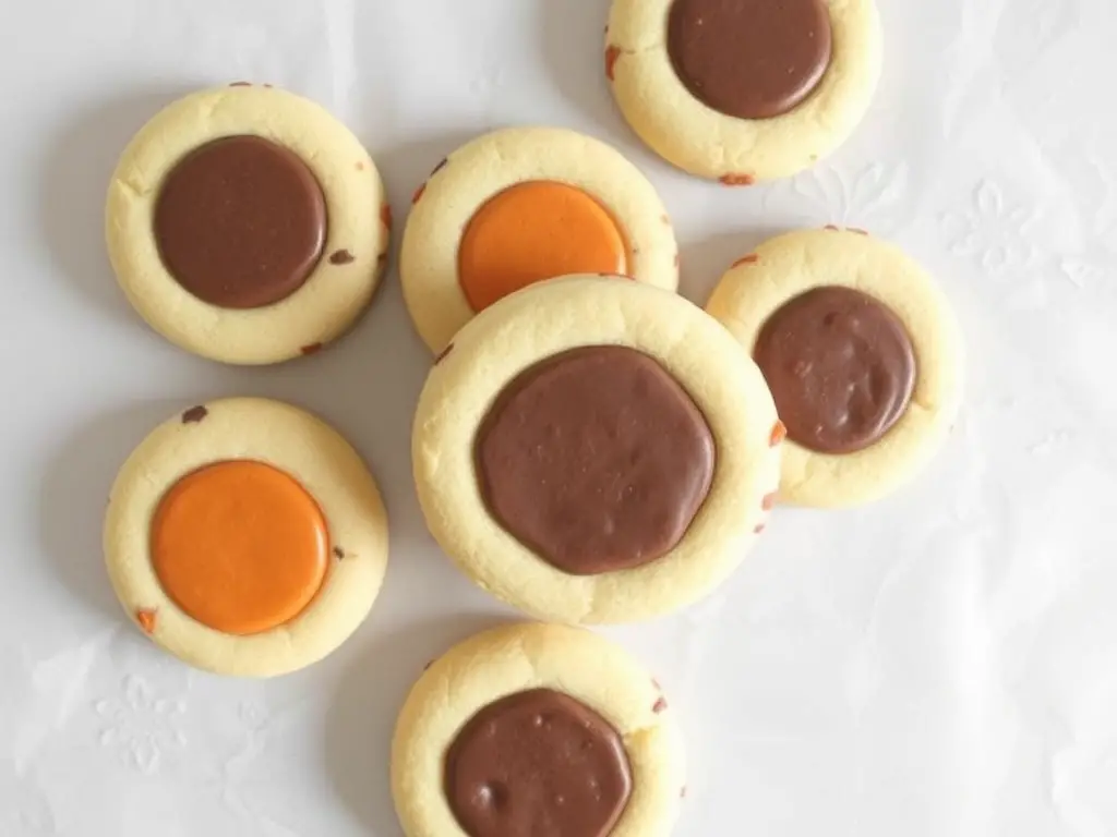 Round Thanksgiving sugar cookies decorated with royal icing in autumn colors, featuring festive designs like pumpkins, leaves, and “Thankful” text.